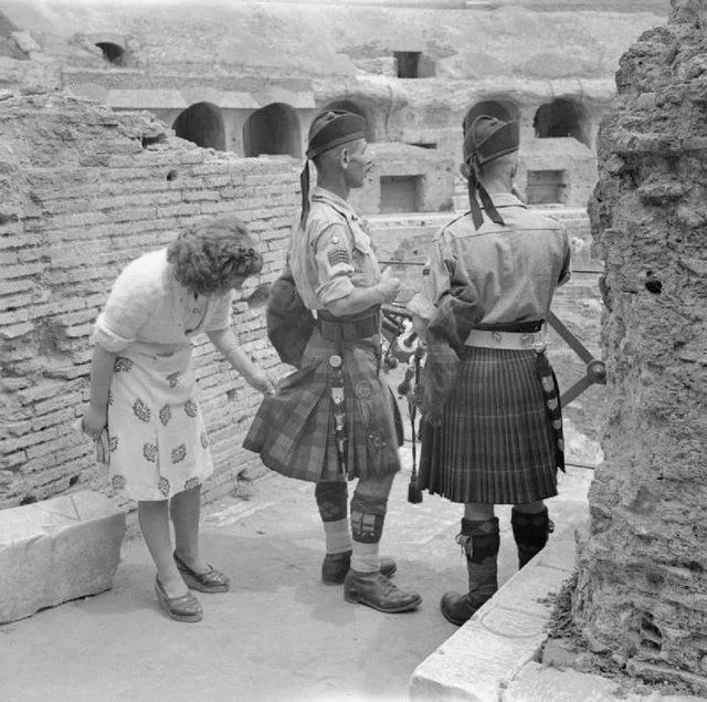 Một quý bà người Ý đang kiểm tra chiếc váy của anh lính Scotland xem có thật không vì lần đầu được